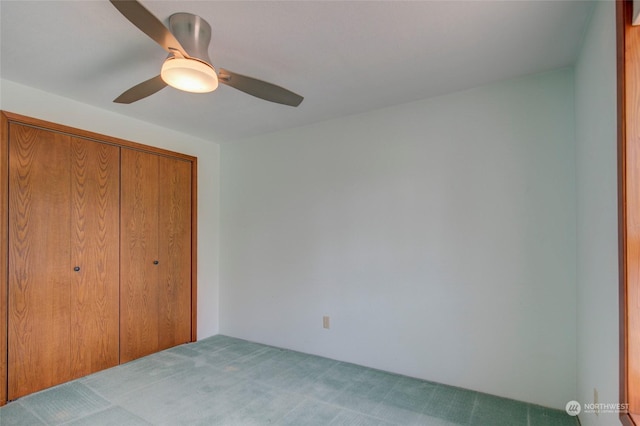 unfurnished bedroom with ceiling fan, a closet, and carpet