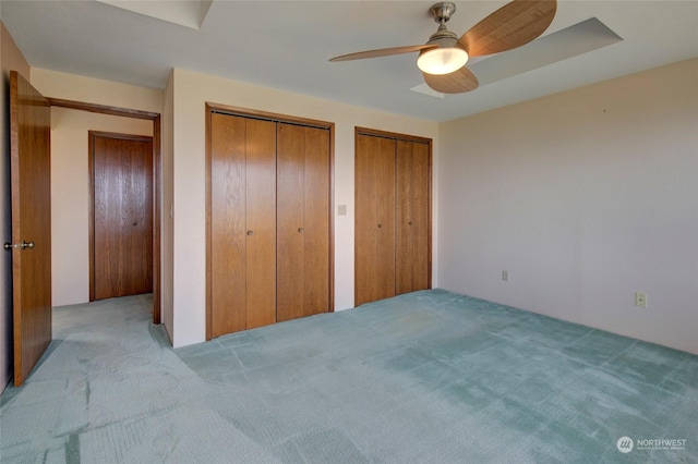 carpeted bedroom featuring two closets and a ceiling fan
