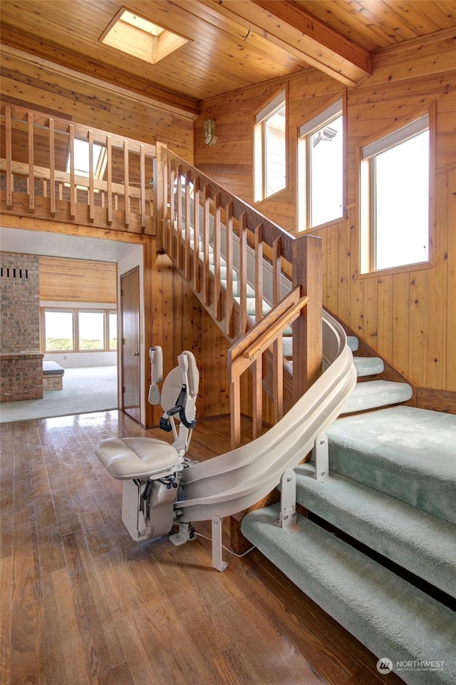 stairs with wooden walls and wood finished floors