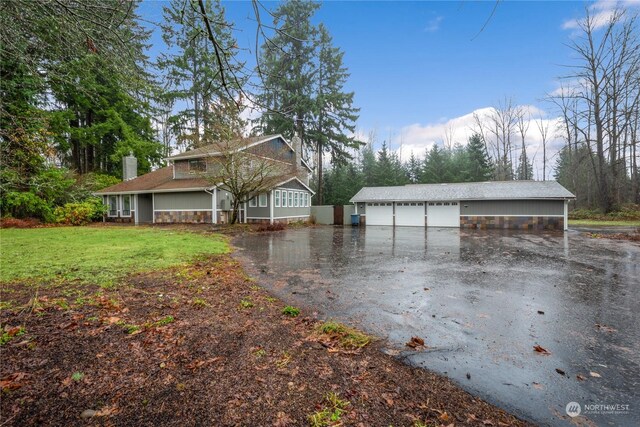 exterior space featuring an outdoor structure, a garage, and a lawn