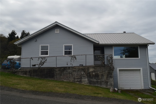 view of property exterior featuring metal roof and an attached garage