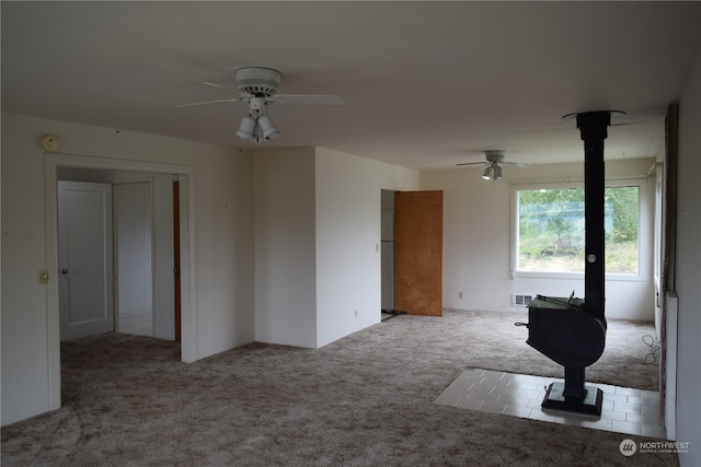 empty room with visible vents, a ceiling fan, and carpet flooring