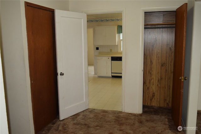 hallway with carpet floors and tile patterned floors