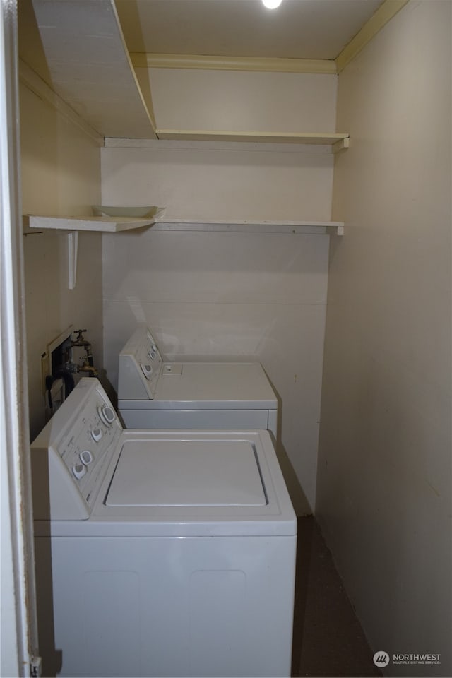 clothes washing area featuring ornamental molding, laundry area, and washing machine and clothes dryer