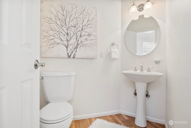 bathroom with hardwood / wood-style floors and toilet