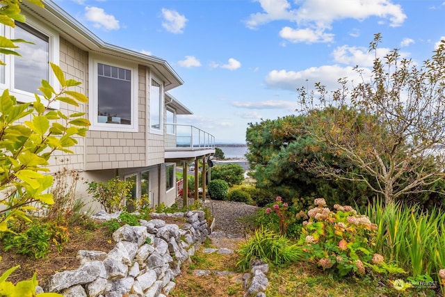 view of home's exterior featuring a balcony and a water view