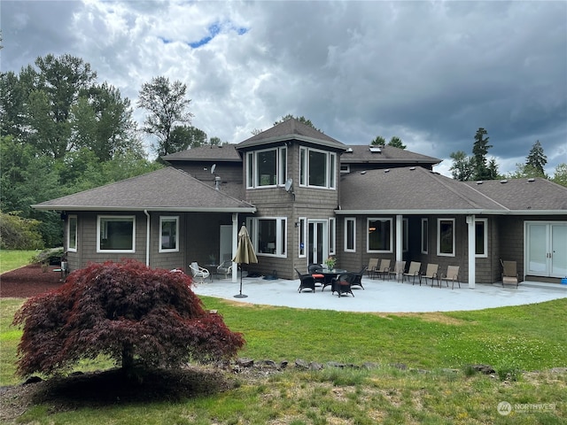 rear view of property featuring a lawn and a patio area