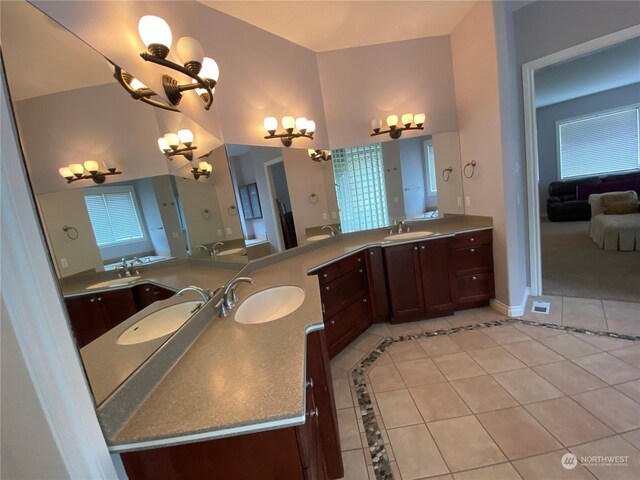 bathroom featuring tile patterned floors, a towering ceiling, and vanity