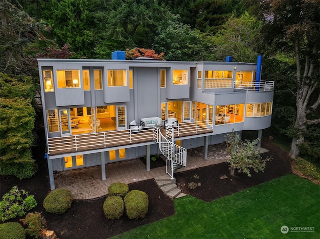 back of property featuring stairs and a balcony