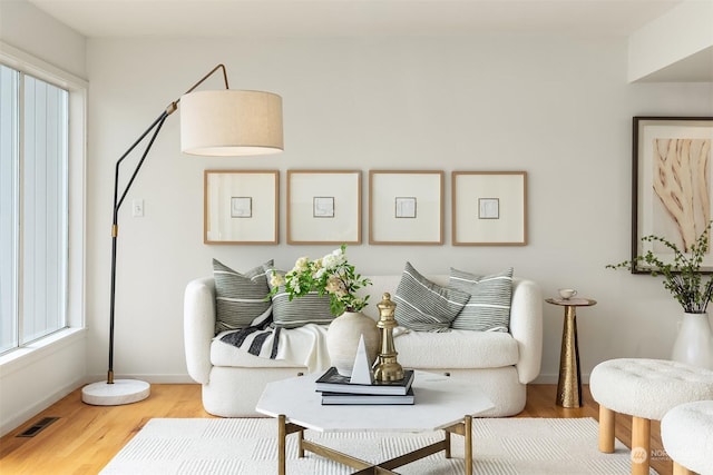 sitting room featuring visible vents, baseboards, and wood finished floors