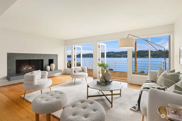 living room with light wood-type flooring and a water view