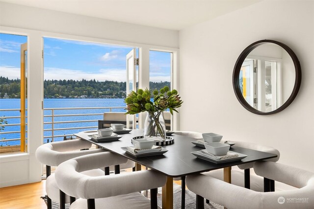 dining room featuring a water view and hardwood / wood-style flooring