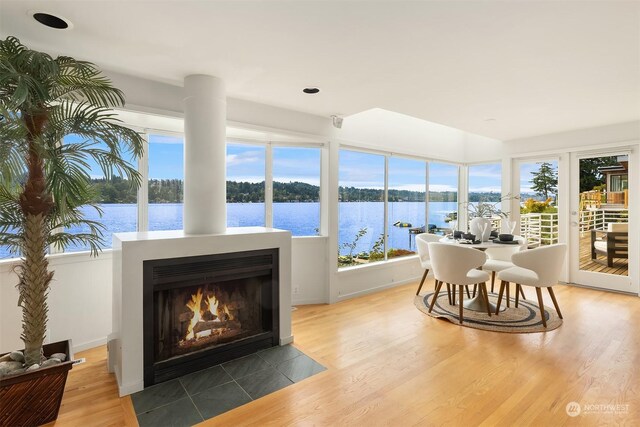 sunroom featuring a water view