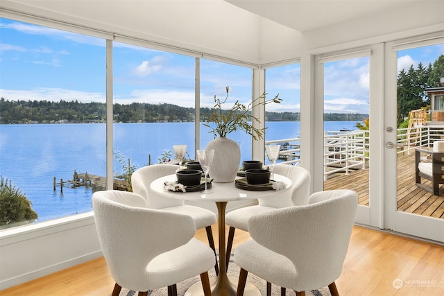 sunroom featuring a water view