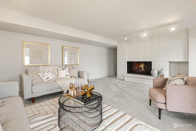 carpeted living room featuring a fireplace and rail lighting