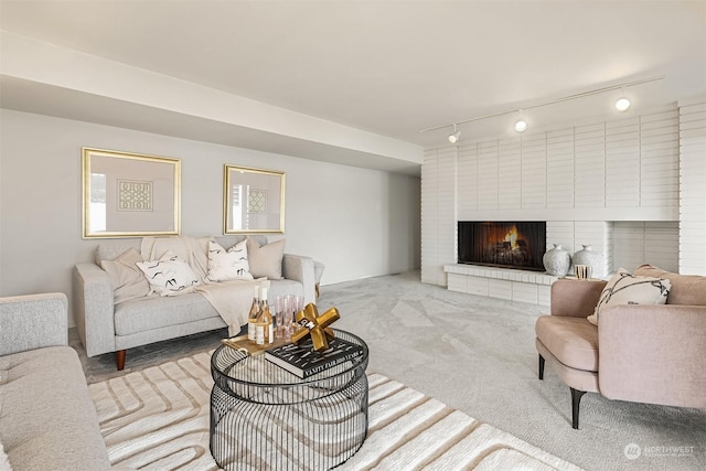 carpeted living room with a fireplace and rail lighting