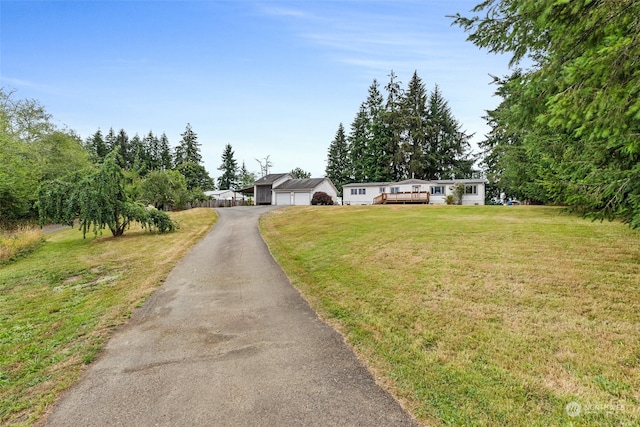 view of front of home featuring an outbuilding, a garage, and a front yard