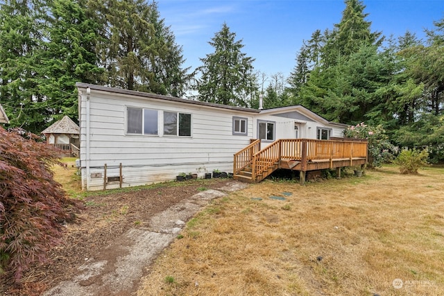 rear view of property featuring a lawn and a wooden deck