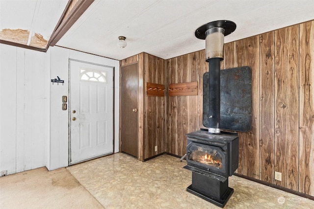 entryway with wood walls and a wood stove