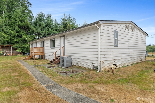 view of home's exterior with a lawn and cooling unit