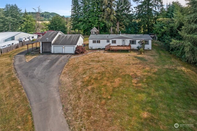 single story home with a garage, a wooden deck, an outdoor structure, and a front yard