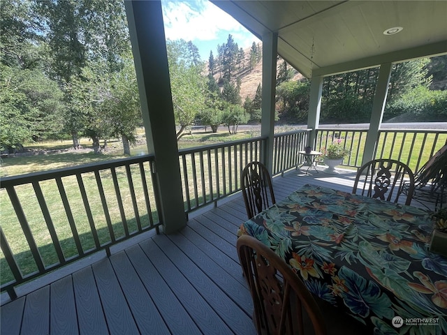 wooden terrace featuring a yard