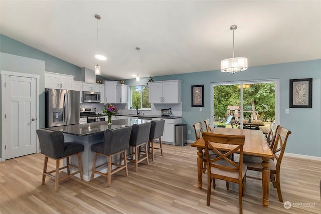 kitchen featuring sink, white cabinetry, a center island, pendant lighting, and stainless steel appliances