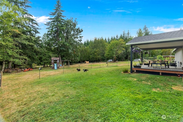 view of yard featuring a wooden deck and a playground