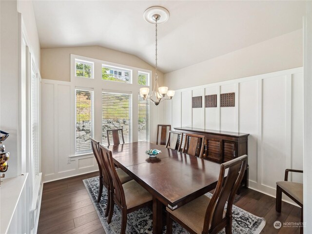 dining area featuring lofted ceiling, dark wood-type flooring, and an inviting chandelier