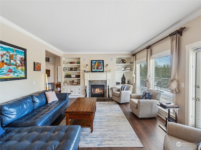 living room featuring ornamental molding, built in shelves, a fireplace, and dark hardwood / wood-style floors