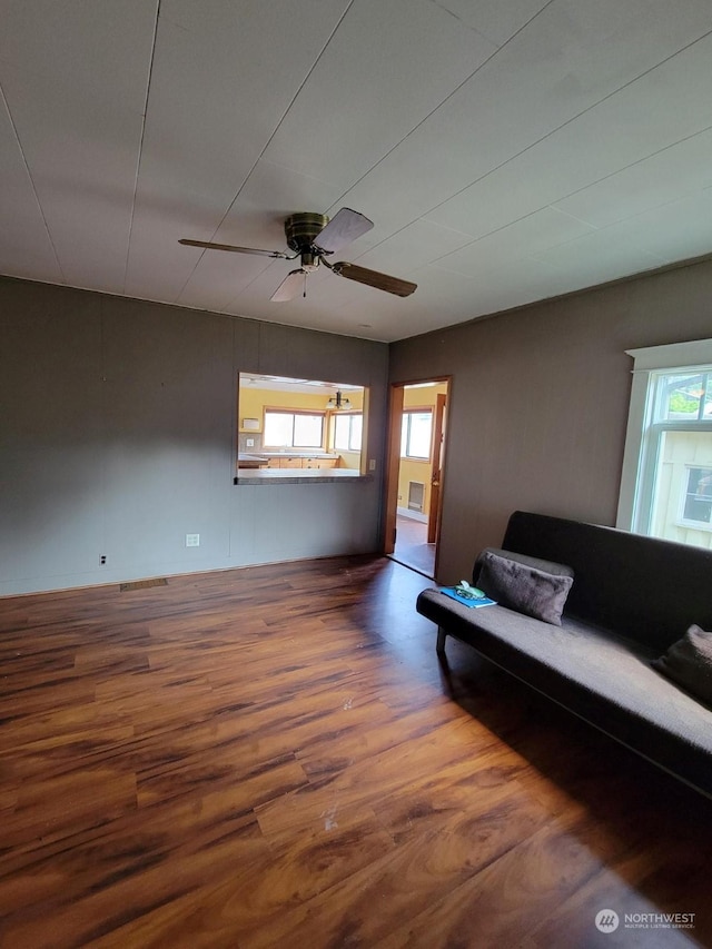 unfurnished living room with wood-type flooring and ceiling fan