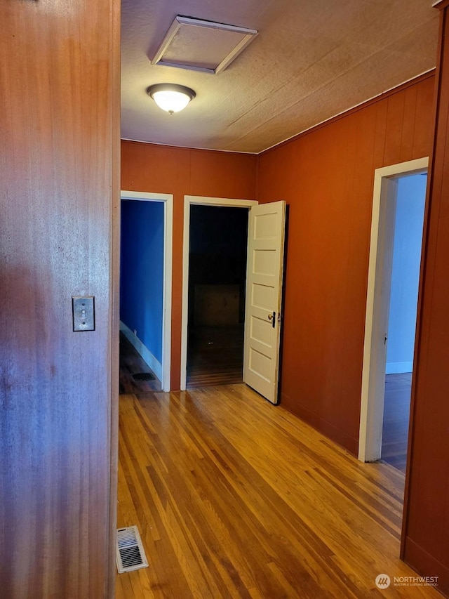 interior space with hardwood / wood-style flooring and wood walls