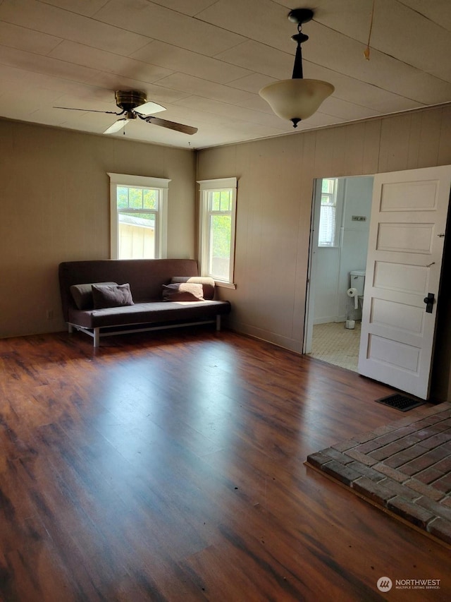 unfurnished living room featuring dark hardwood / wood-style floors and ceiling fan