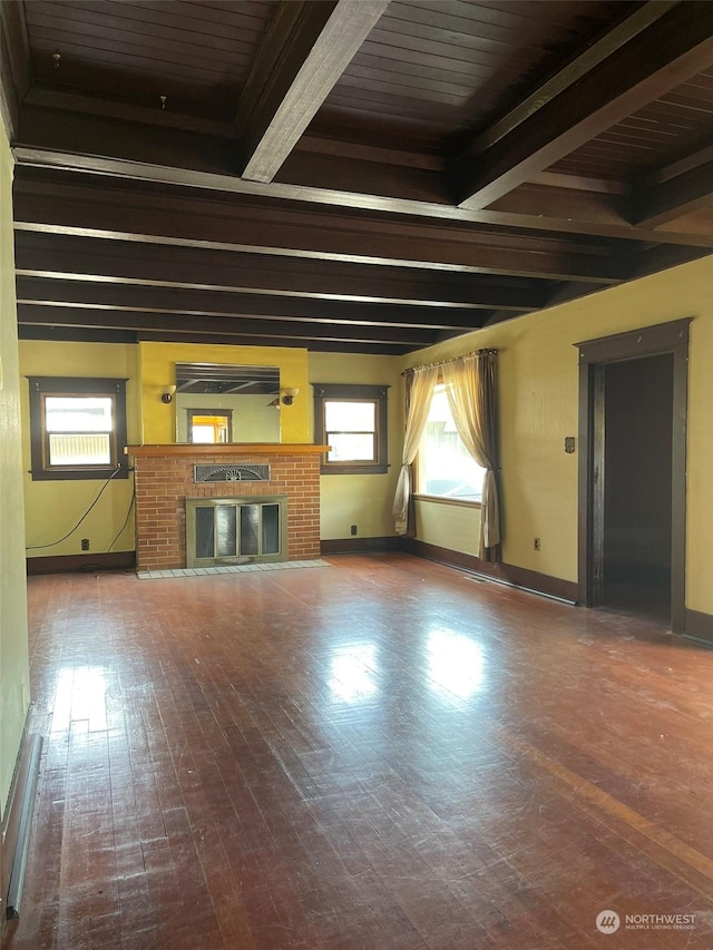 unfurnished living room featuring beamed ceiling, hardwood / wood-style flooring, and a fireplace