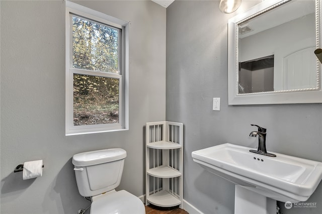 bathroom featuring a wealth of natural light, sink, and toilet