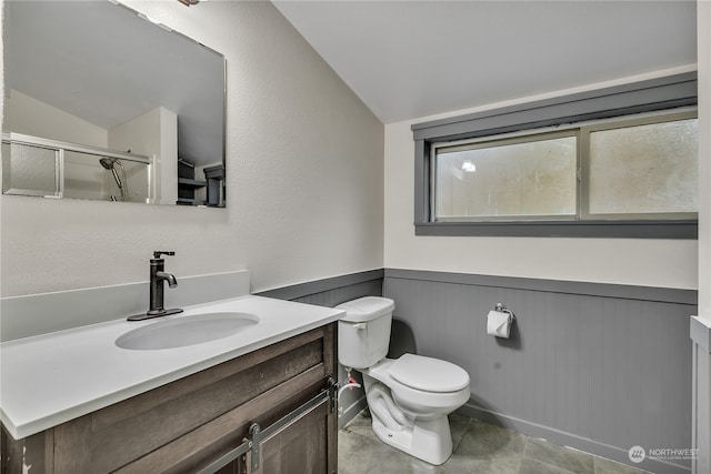 bathroom featuring vanity, vaulted ceiling, tile patterned flooring, toilet, and a shower with shower door