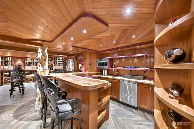 kitchen featuring wood counters, sink, wood ceiling, and light parquet floors