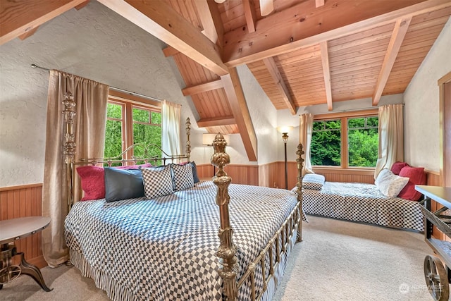 carpeted bedroom with wooden ceiling, lofted ceiling with beams, multiple windows, and wood walls