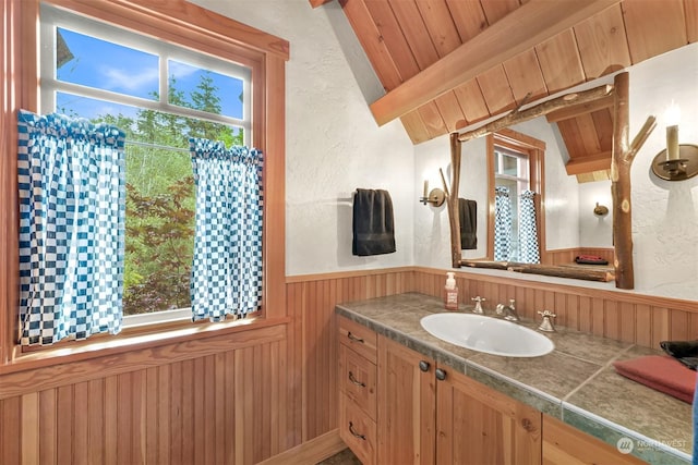 bathroom featuring vanity, wood ceiling, beam ceiling, and wood walls