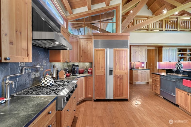 kitchen with beamed ceiling, range hood, light hardwood / wood-style flooring, and paneled built in refrigerator