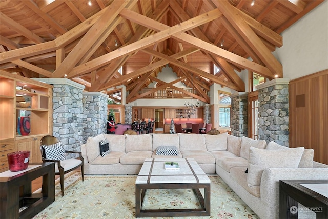 living room featuring decorative columns, high vaulted ceiling, wooden ceiling, and beam ceiling