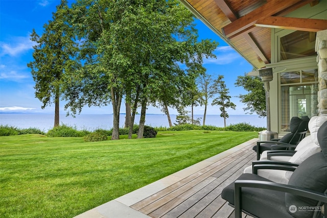 wooden deck with a water view and a lawn