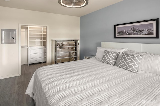 bedroom with dark hardwood / wood-style floors, electric panel, and a closet