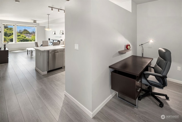 office with track lighting and hardwood / wood-style flooring