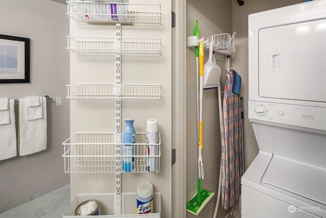 laundry room featuring stacked washing maching and dryer and tile patterned floors