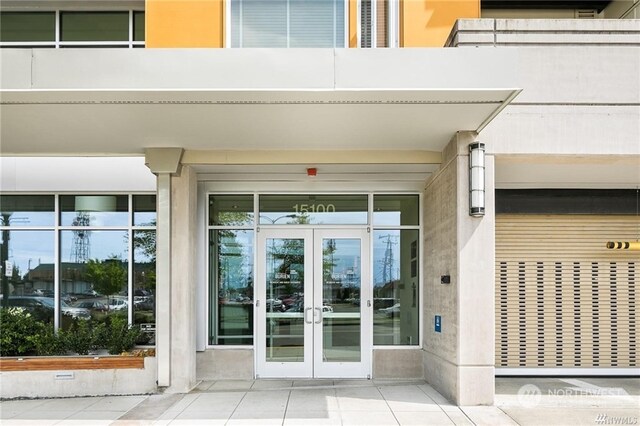 view of exterior entry featuring a balcony and french doors