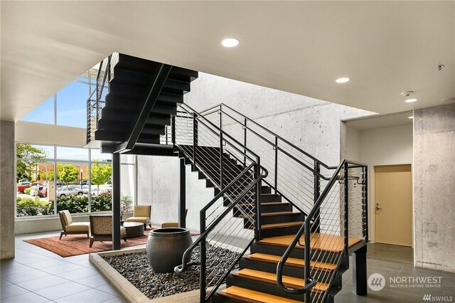 staircase with tile patterned flooring and a high ceiling