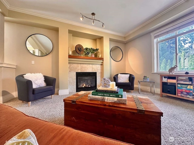 carpeted living room featuring a tile fireplace, crown molding, and track lighting