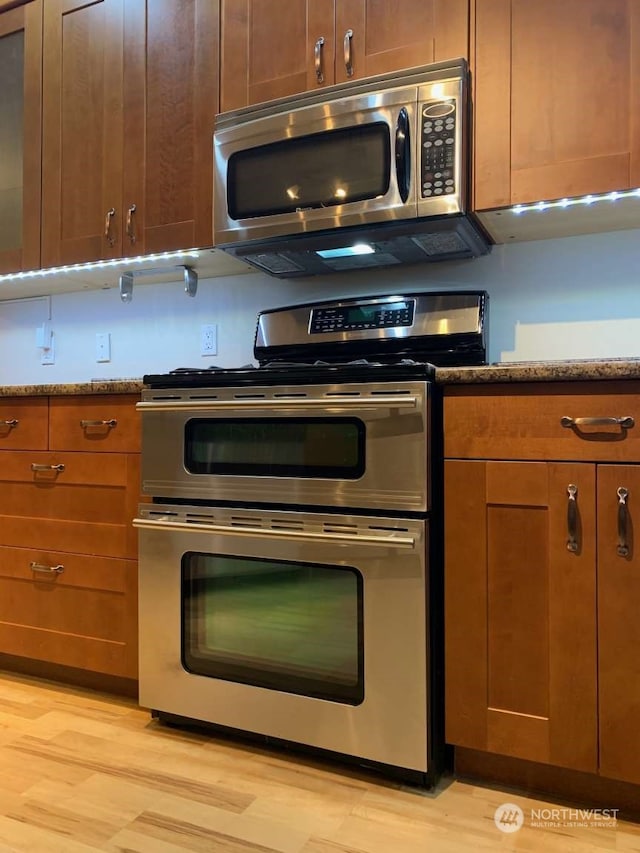 kitchen featuring light hardwood / wood-style floors, appliances with stainless steel finishes, and light stone countertops