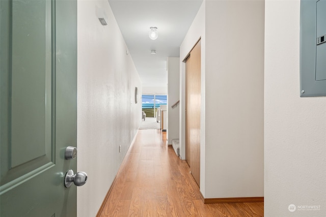 corridor featuring electric panel and light wood-type flooring